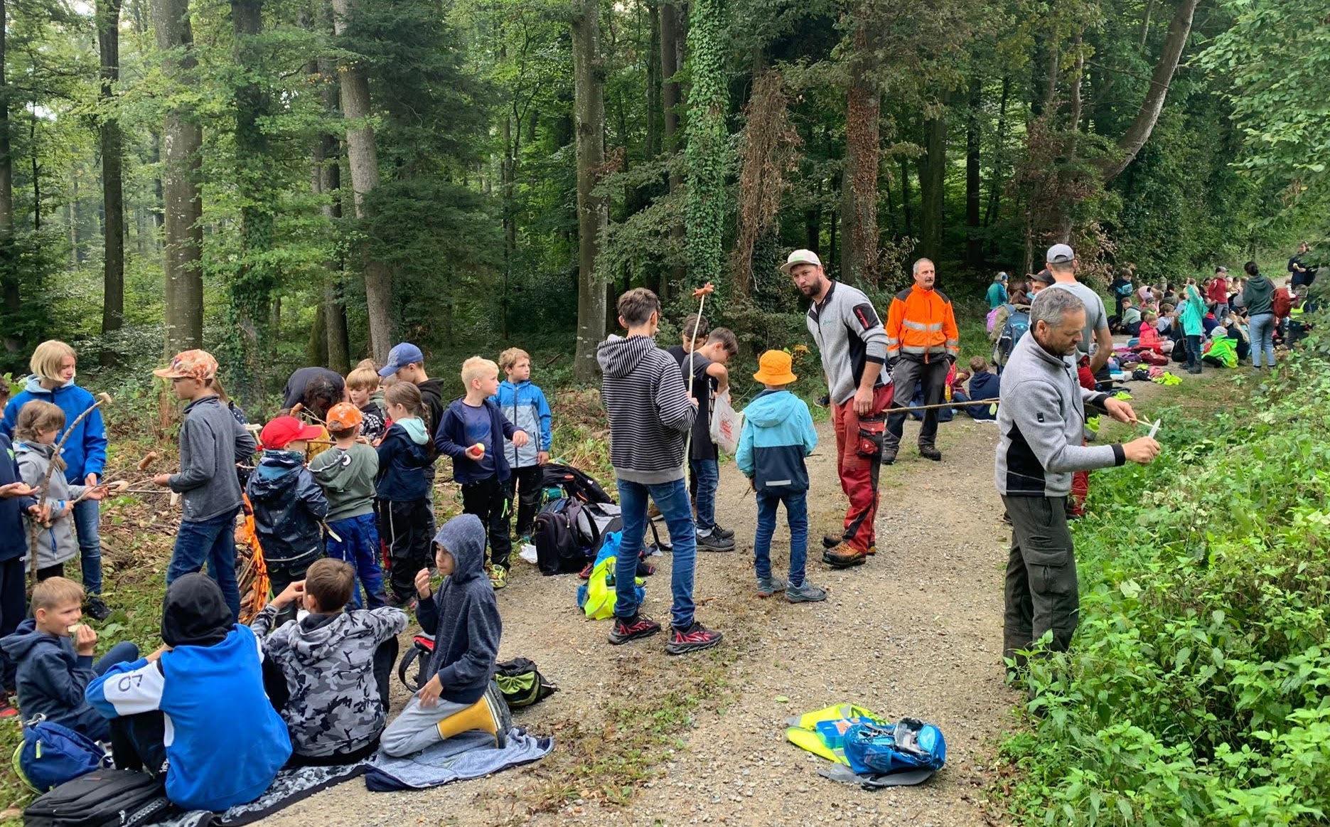 Eine ausgiebige Pause mit Feuern und Würste braten gehört dazu. Die Kinder sammeln Holz und das ThurForst-Team schnitzt Bratstecken